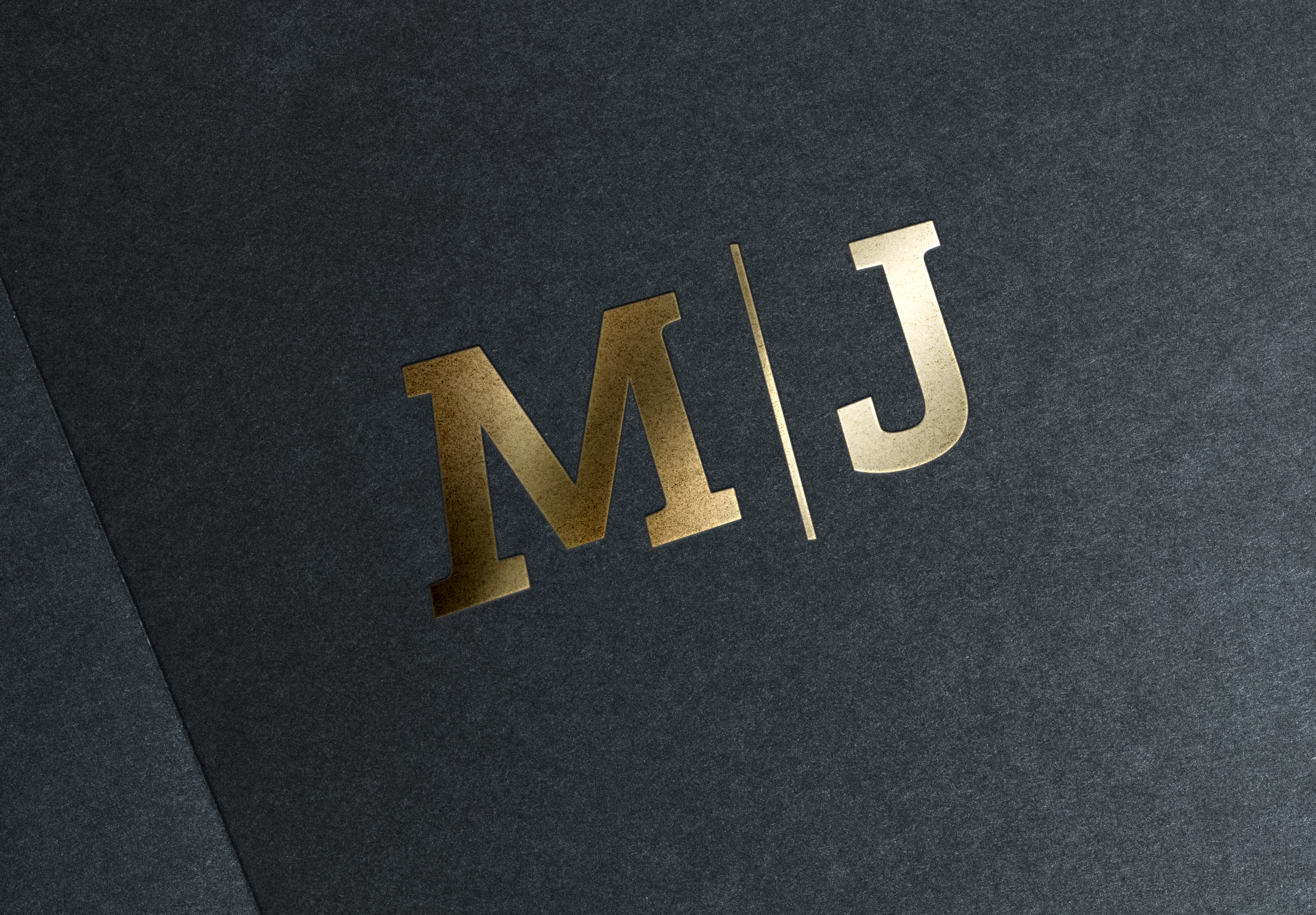 M/J gold logo on black paper