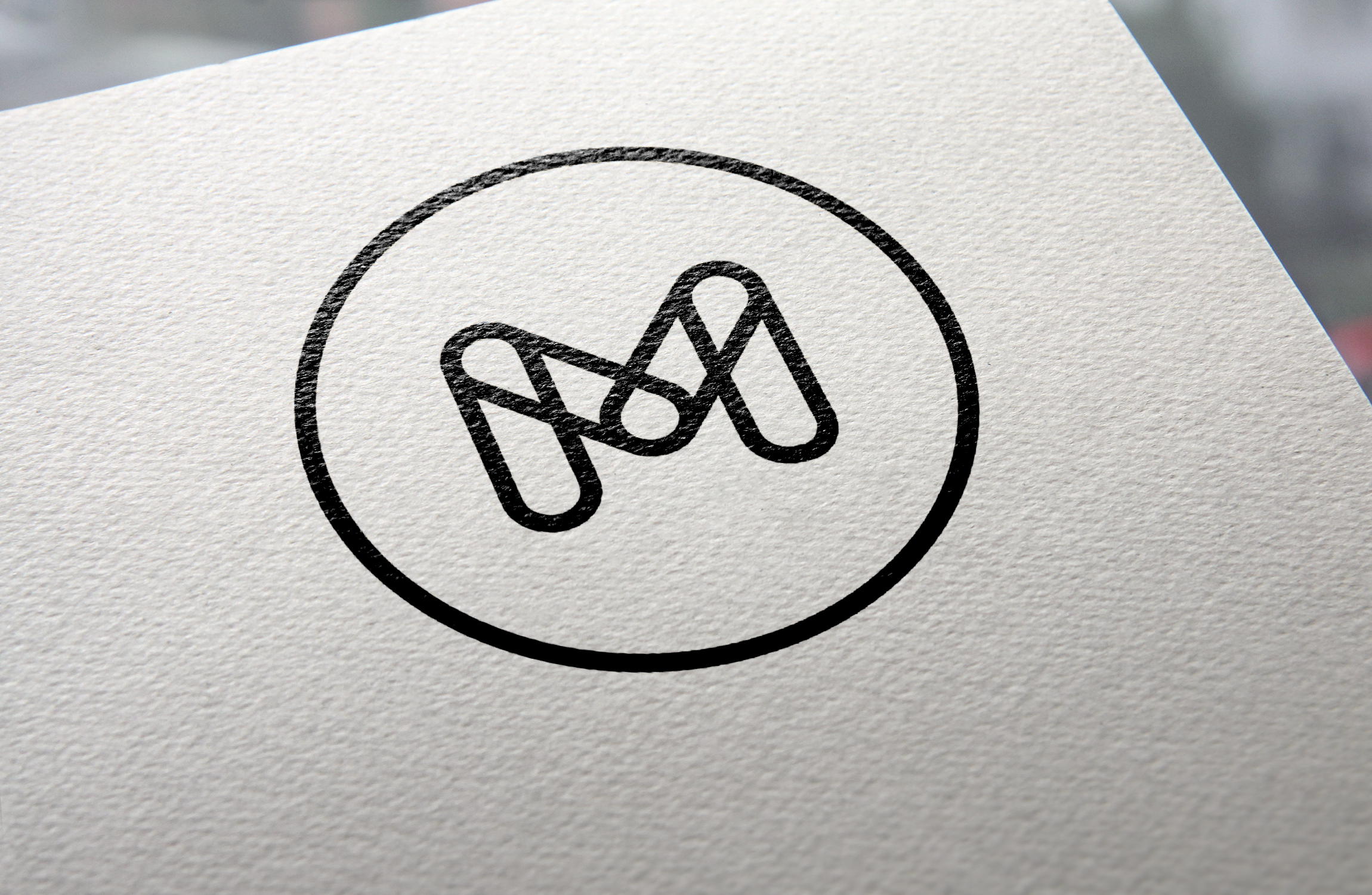 M black logo on white paper