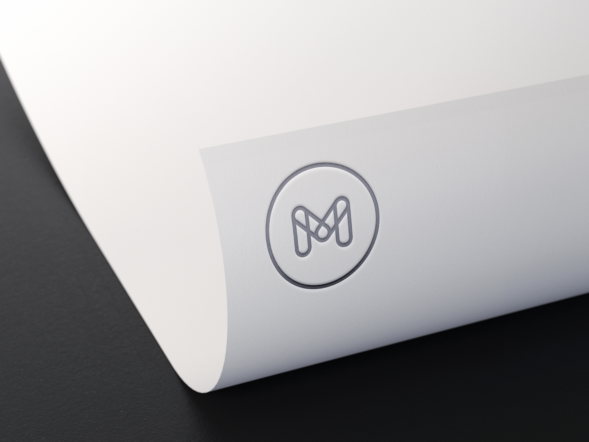 M silver logo on white paper